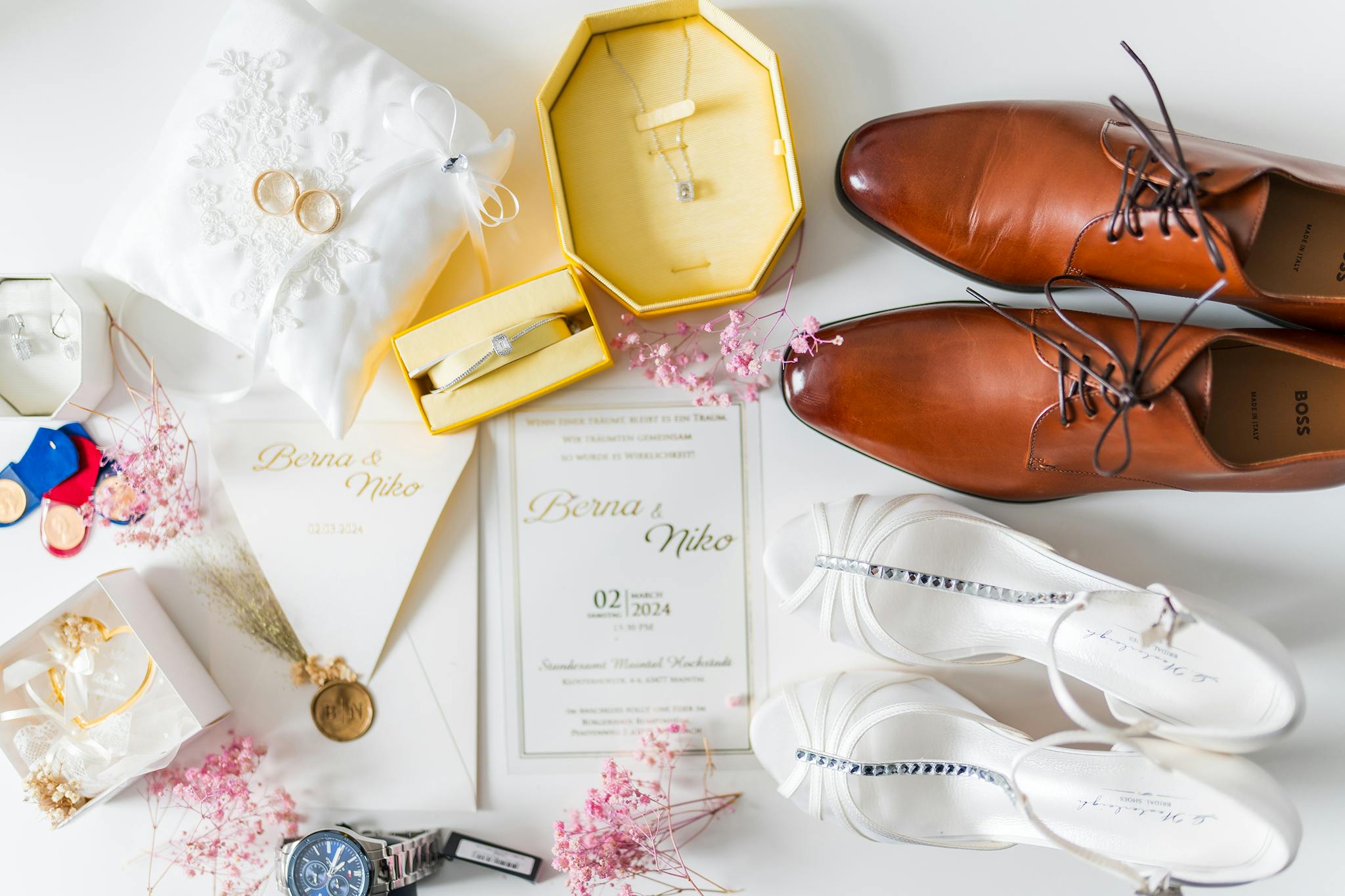 Flat lay of elegant wedding accessories including shoes, jewelry, and invitations.