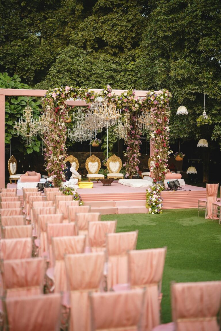 Romantic outdoor wedding ceremony with floral arches and elegant seating on a sunny day.