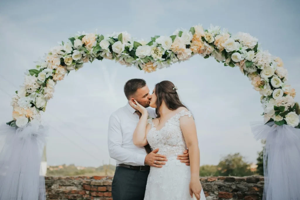 Wedding Officiant in Arizona Kissing Under Wedding Arch